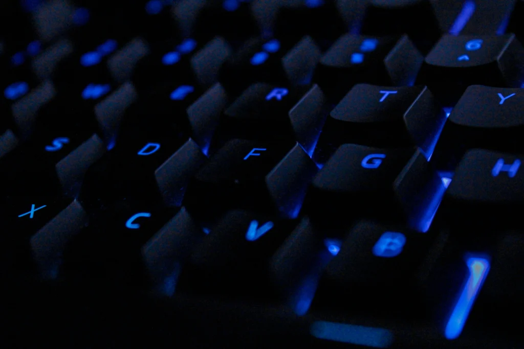 Close up of a backlit keyboard with illuminated keys representing keyboard reprinting and refurbishment services
