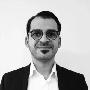 Corporate headshot of a TellusRem team member wearing glasses and business attire