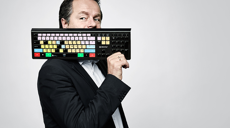 Professional holding a keyboard with colorful reprinted keys demonstrating keyboard reprinting and customization services